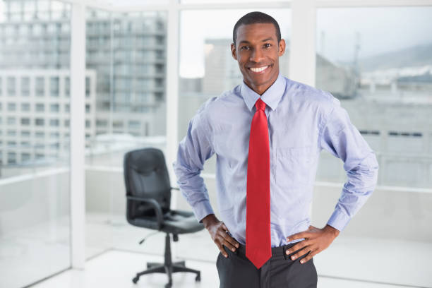 istock Elegant smiling Afro businessman standing in office 852325288