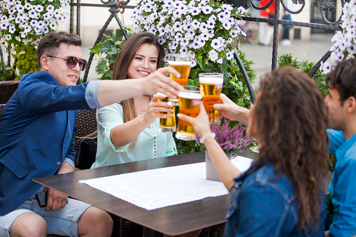 Group of young cheerful people drinking beer in a beer garden.