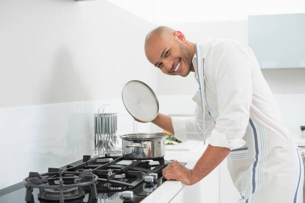 istock Smiling young man preparing food in kitchen 852400150