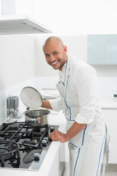 istock Side view of a smiling man preparing food in kitchen 852400158