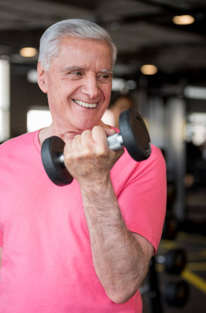 istock Senior man exercising at the gym with free weights 852401262