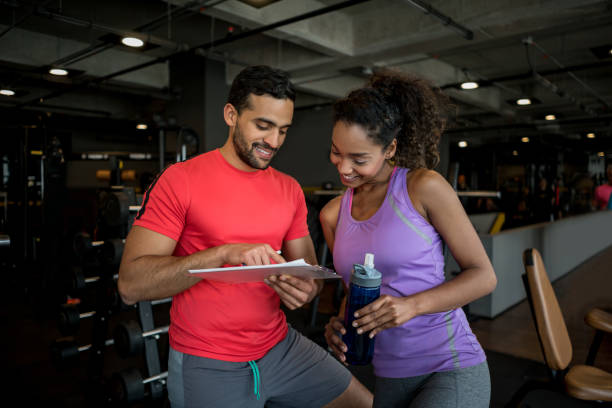 istock Woman at the gym talking to her personal trainer 852401404