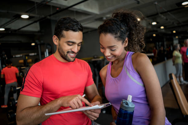 istock Personal trainer talking to a woman at the gym 852401444