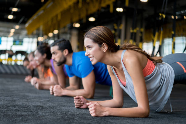 Group of people at the gym in a suspension training class Group of people exercising at the gym in a suspension training class â fitness concepts exercise class stock pictures, royalty-free photos & images