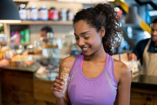 Woman eating a protein bar at the gym