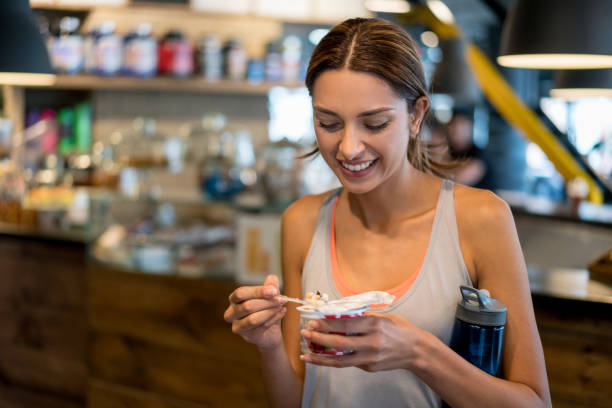 ジムで健康的なスナックを食べる女 - sport food exercising eating ストックフォトと画像