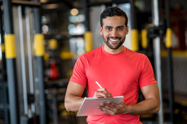 glücklich privattrainer trainieren im fitnessstudio - fitness trainer stock-fotos und bilder