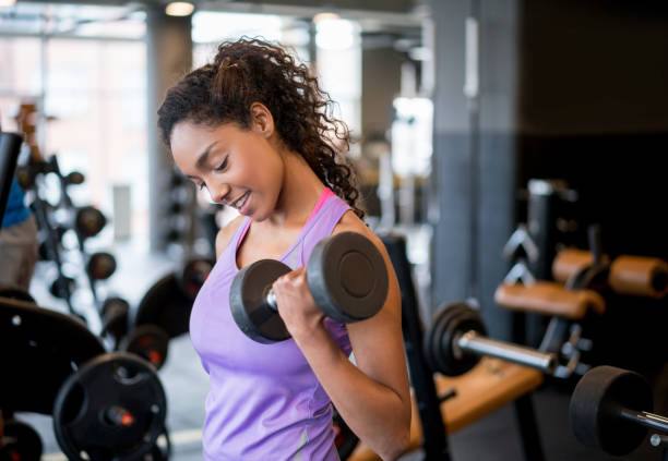 istock Athletic woman exercising at the gym lifting weights 852401738
