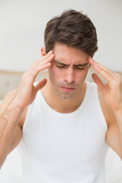 istock Close up of a man suffering from headache in bed 852410798