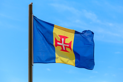 Flag of Madeira archipelago. Blue-gold-blue vertical triband with a red-bordered white Cross of Christ in the center