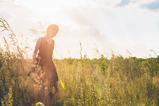 young fashionable woman enjoying in grassy field.