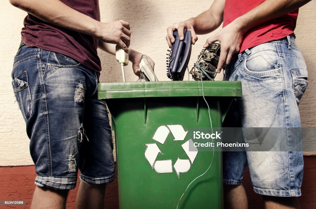 E concetto di rifiuti, due uomini lanciano elettronica - Foto stock royalty-free di Rifiuto elettronico