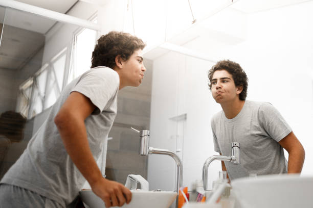 Boy making mouthwash in the morning A young boy doing her mouth hygiene in the morning. tawny stock pictures, royalty-free photos & images