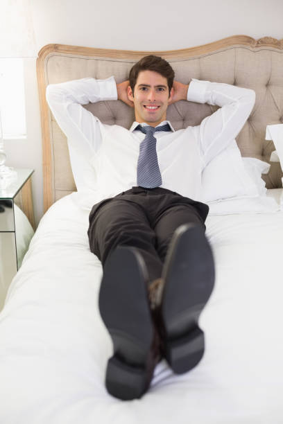istock Relaxed smiling well dressed man lying in bed 852415746