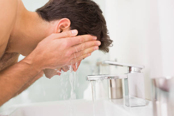 istock Shirtless young man washing face in bathroom 852418628