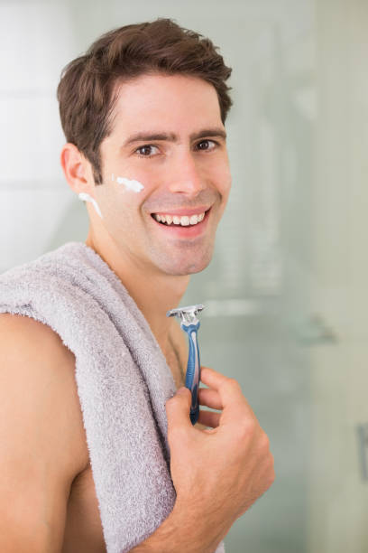 istock Smiling handsome man shaving in bathroom 852418720