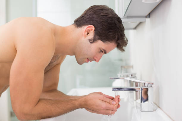 istock Shirtless young man washing face in bathroom 852418772