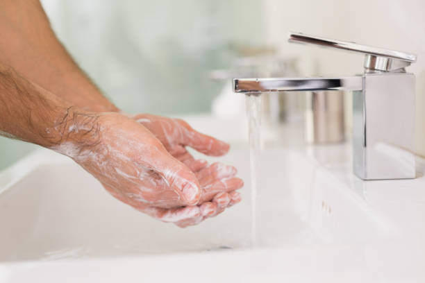 istock Washing hands with soap under running water at bathroom sink 852418816