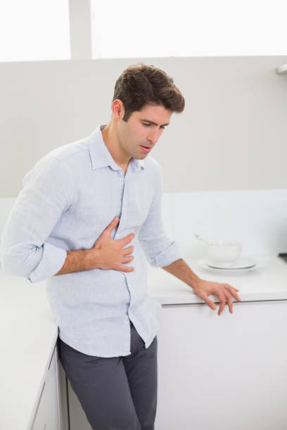 istock Casual man with stomach pain in the kitchen 852421916