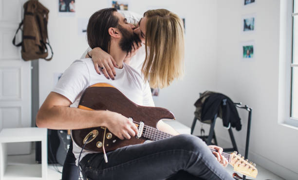 istock Lovely young couple playing guitar together 852422220
