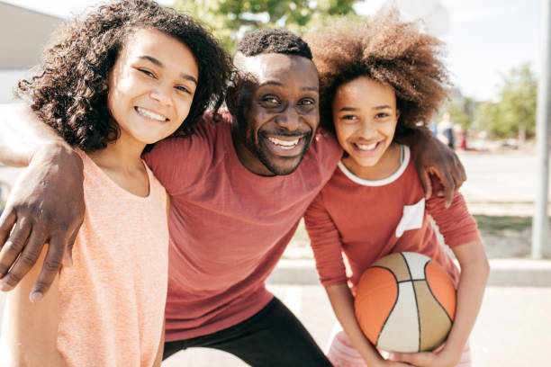 istock Dad and daughters  posing with basketball ball 852422544