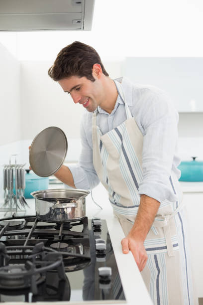 istock Smiling young man preparing food in kitchen 852422692
