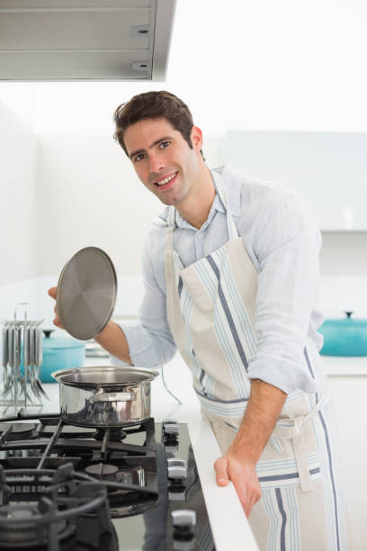 istock Smiling young man preparing food in kitchen 852422696