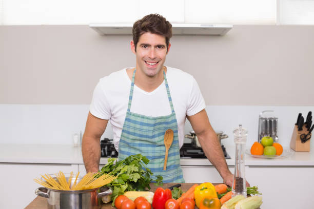 istock Smiling young man with vegetables standing in kitchen 852424974