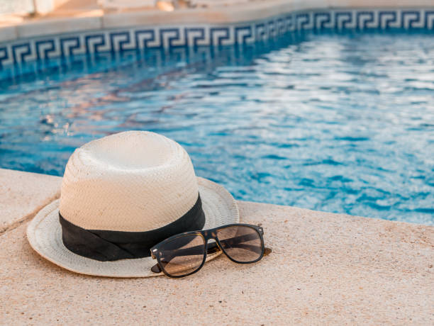 istock Hat and sunglasses at the pool. Summer holiday concept. 852425152