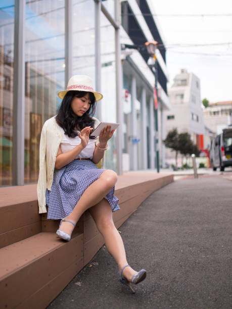 istock Young woman reading message on digital table in urban city 852425900