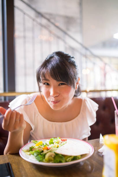 istock Young woman eating salad in cafe 852426066