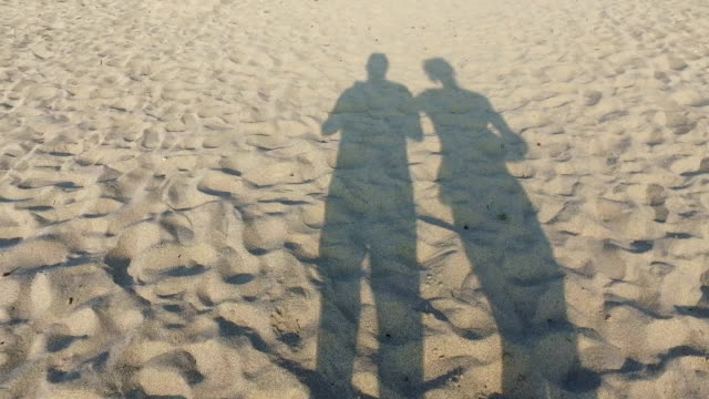 Pareja de jóvenes amantes caminando por la playa con sombras romántico en  la arena descarga videos de stock gratis y clips de Largo - Longitud
