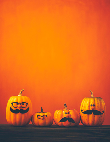 Cute pumpkin characters on bright orange background