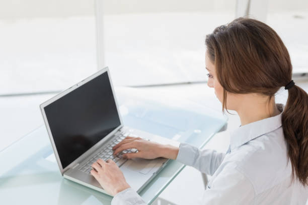 istock Brown haired businesswoman using laptop in office 852443042