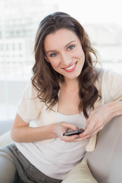 istock Portrait of relaxed young woman text messaging on sofa 852445998