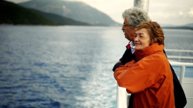 Senior couple talking and enjoying the view while riding on ferry.