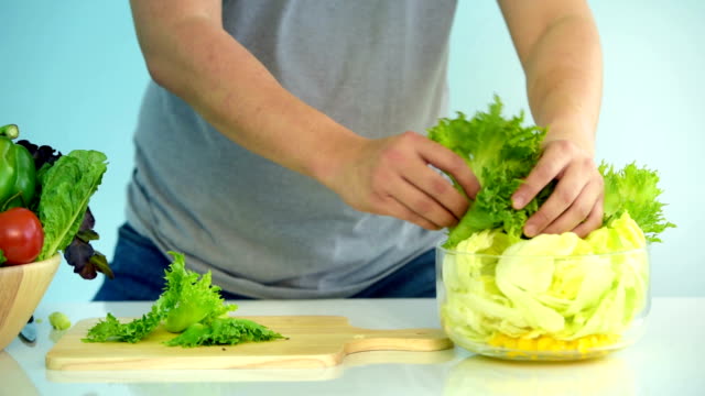 Young husband prepare salad for wife
