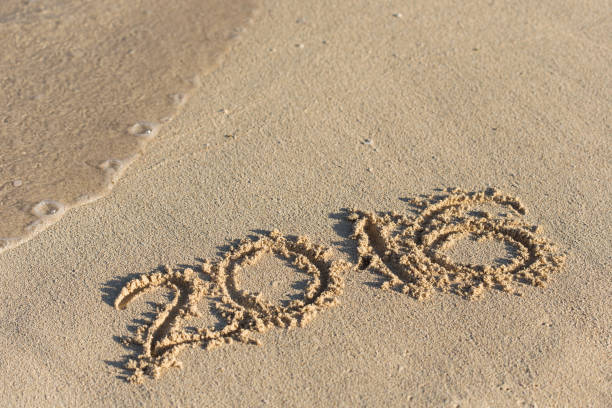 istock Inscription 2016 on sandy beach with wave's foam 852463006