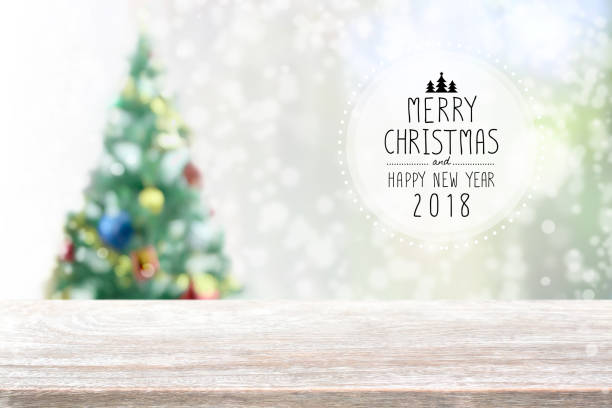 istock Wood table top on blur with bokeh christmas tree background with snowfall - can be used for display or montage your products 852464210
