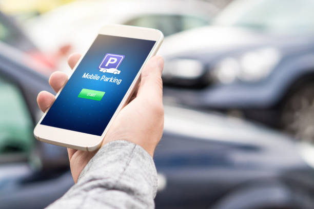 istock Mobile parking app on smartphone screen. Man holding smart phone with car park application in hand. Internet payment online with modern device. 852475614