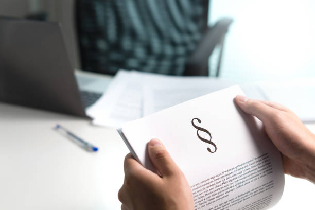 man holding a legal document in hand with a section sign home. lawyer holding law paper in office. - clause imagens e fotografias de stock