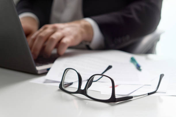istock Business man writing with laptop in office with glasses on table. 852477996