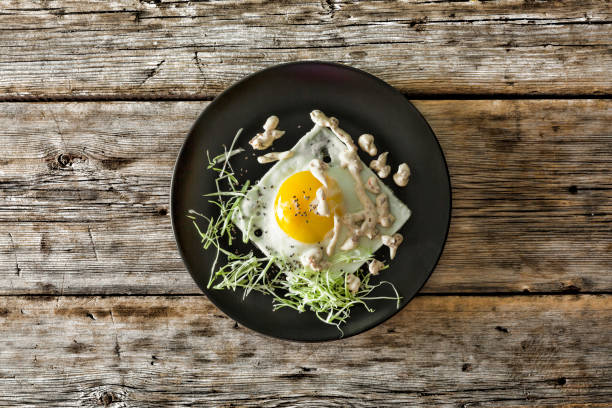 istock Healthy breakfast. Fried egg on a black plate with micro-green and quinoa. Top view, closeup. 852481028