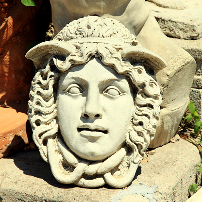 Stone carved Medusa head, Italy. Square vintage toned image