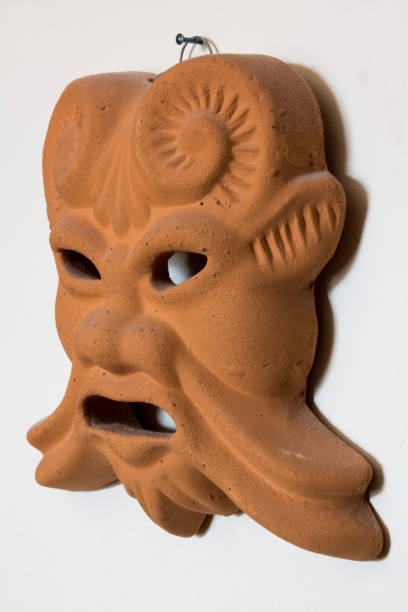 istock Ocher and brown terracotta ancient mask hanging on white background 852488160