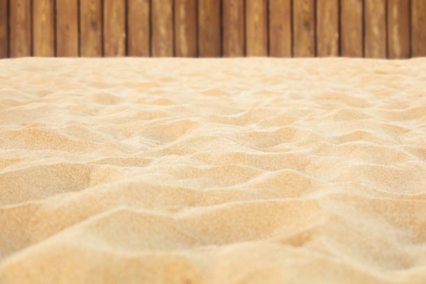 Clean beach sand and wooden fence on background