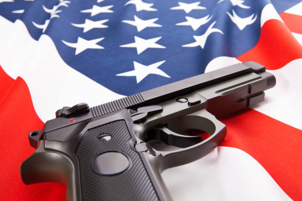 istock Handgun lying on satin US flag - close up studio shoot 852520634