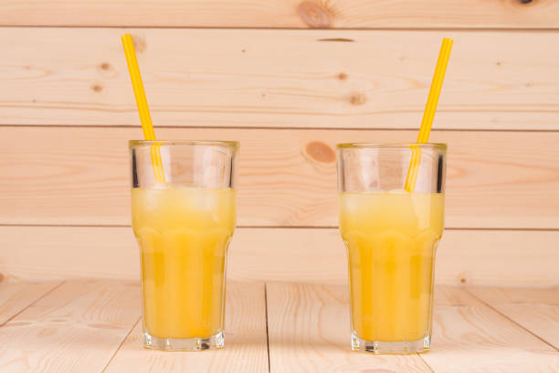 Glasses of fresh orange juice. Located in the wooden background. Close-up.