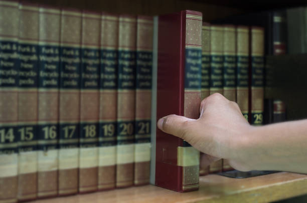 istock closeup hand selecting book from a bookshelf in library 852570988