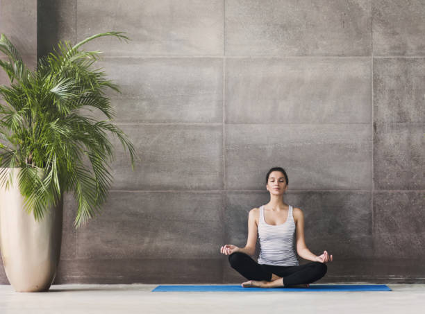 young woman practicing yoga. Meditation and harmony concept Young girl meditating in yoga class yoga studio photos stock pictures, royalty-free photos & images